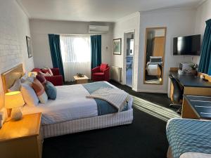 米塔贡Grand Country Lodge Motel的酒店客房设有床和客厅。