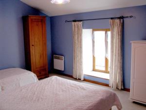 Chez laure的一间蓝色卧室,配有两张床和窗户