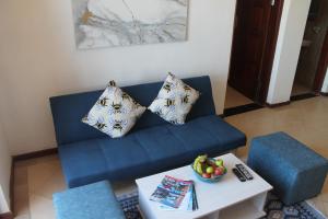 奔巴岛Wharf Side Inn的客厅配有带枕头和桌子的蓝色沙发