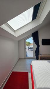 杜布罗夫尼克Apartments Villa Alba的一间卧室设有天窗和一张红色地毯。