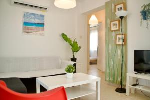 梅内乌Yiallos Village Apt. A101的客厅配有白色沙发和红色椅子