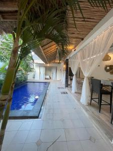 金巴兰Villa deluna的一座房子里棕榈树的游泳池