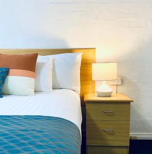 米塔贡Grand Country Lodge Motel的一张带床头柜的床,上面有灯