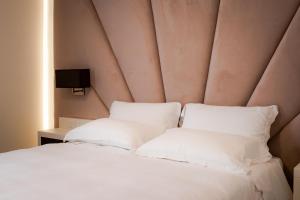 比森齐奥营M2 Hotel的一张带白色枕头的床