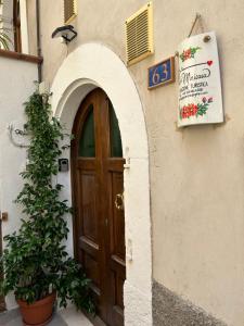 PacentroLa Minicasa的建筑的门,有标志和植物