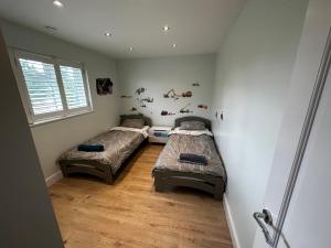 埃尔沃斯Luxury West London 3BR House, Cul De Sac的带窗户的客房内设有两张单人床。