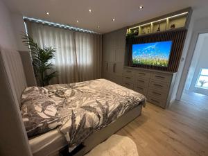 埃尔沃斯Luxury West London 3BR House, Cul De Sac的一间卧室配有一张床和一台平面电视