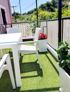 阿洛尼索斯古镇Cherry's apartment的种植了植物的阳台配有白色的桌椅