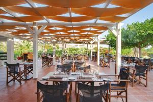 斯卡拉埃雷索Aeolian Village Beach Resort的屋顶下设有桌椅的餐厅