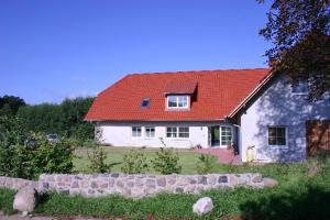 旧施韦林Landhaus Fischersruh Plauer See的一座大型白色房屋,设有红色屋顶