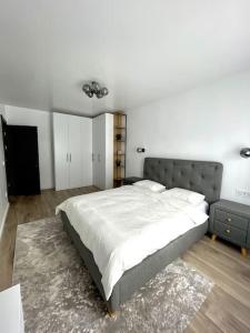 拉姆尼库沃尔恰Apartament central 2 camere的一间卧室设有一张大床和白色的墙壁