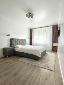 拉姆尼库沃尔恰Apartament central 2 camere的一间卧室设有一张大床和一个窗户。