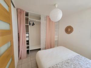 GaillonAppartement avec terrasse的一间带一张床和一个衣柜的小卧室