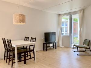 海宁Newly Renovated Two Bedroom Apartment In City Center Of Herning的一间带桌椅和电视的用餐室