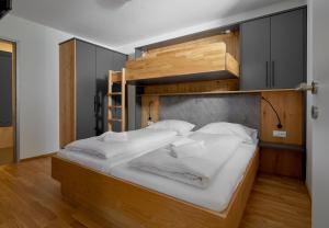 瓦尔德阿尔贝格Zapfig Living Arlberg的卧室配有带白色床单的双层床