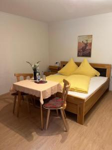 巴特莱辛哈尔Fagererhof的一间卧室配有一张带桌子和黄色枕头的床。