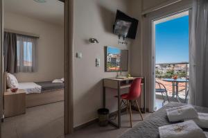 新马尔马拉斯Sunshine Apartments的一间卧室配有一张床、一张书桌和一个窗户。