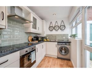 贝尔法斯特Central Belfast Apartments BELFAST WORK-REST-PLAY R&R的厨房配有白色橱柜、洗衣机和烘干机