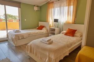 奥利维拉Amazing Vila close to Sitges, jacuzzi, swimming pool & exellent views的配有两张床的客房,设有绿色的墙壁和窗户