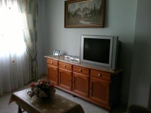 林孔-德拉维多利亚La Kentia的客厅配有木梳妆台上的电视