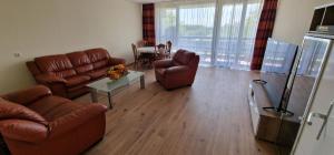 科隆City Apartment Cologne-Weiden的客厅配有棕色皮革家具和桌子