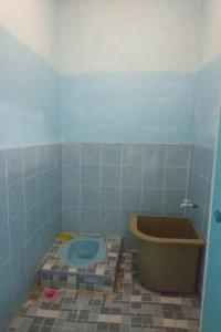 TonggingPenginapan Rindu Alam Soala Gogo的蓝色瓷砖浴室设有卫生间和浴缸