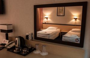 Barentsburg巴伦支堡酒店的镜子中一张配有两张床铺的酒店客房的反射