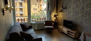 蒂涅Le Rosset的带沙发、电视和窗户的客厅