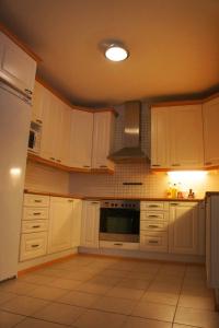 赫尔辛基甜梦旅舍的厨房配有白色橱柜和炉灶烤箱。