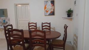 马林迪Crown Apartments的餐桌、四把椅子、一张桌子和一张图片