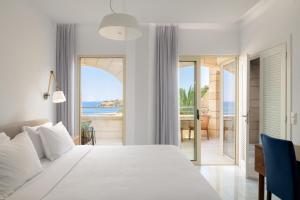 罗希姆诺马卡利斯套房酒店及Spa的一间卧室配有一张床,享有海景