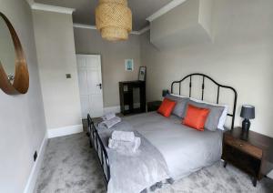 布莱顿霍夫Contemporary beach apartment的一间卧室配有一张带橙色枕头的大床