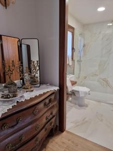 拉维斯瓦尔Turisme Rural Mas Vilà的浴室设有木制梳妆台和镜子