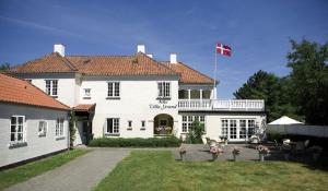 霍恩拜克斯特朗别墅的一座白色的大房子,上面有藤旗