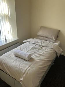 贝里Immaculate 2-Bed Apartment in Bury的一张白色的床,上面有一条毛巾