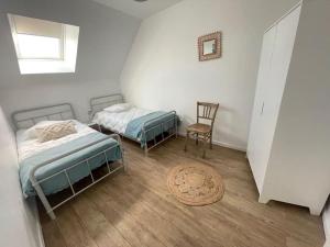 布鲁瓦Côté Loire的两张位于带椅子和地毯的客房内的床铺