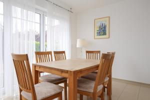 博尔滕哈根Sanddornweg Wohnung 13 a的一间带木桌和椅子的用餐室