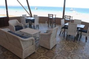 奔巴岛Wharf Side Inn的一间带桌椅和海滩的餐厅
