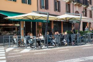 帕多瓦Padova Suites C20的一群人坐在桌子上,拿着雨伞