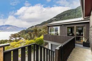 皇后镇The Alpine - Queenstown Holiday Home的带阳台的度假屋,享有水景