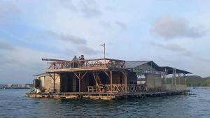 EkasEkas beach floating room and restaurant的水中码头上的房屋