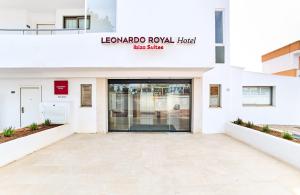 埃斯卡纳Leonardo Suites Hotel Ibiza Santa Eulalia的一座大型白色建筑,设有大玻璃门