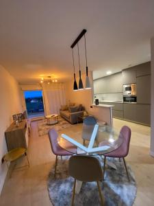 林克勒斯Apartamentos modernos Residencial el Pinar的客厅配有玻璃桌和紫色椅子