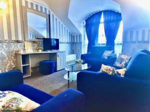 内塞伯尔Boutique Hotel Royal的客厅配有蓝色椅子和电视
