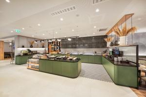 埃施伯恩H+ Hotel Frankfurt Eschborn的一个带绿色橱柜和台面的大厨房