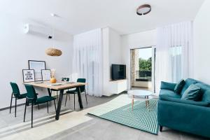 乌马格Apartments San Maris的客厅配有蓝色的沙发和桌子