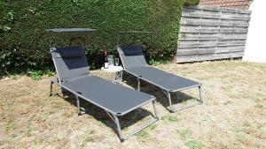 科克赛德a l'aise aan zee的院子里有两把椅子和一张桌子