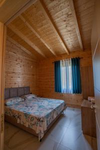 维利波吉The Sea House Velipoje的木制客房内的一间卧室,配有一张床