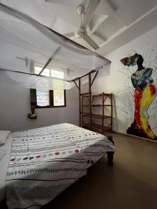 南威Wakanda Nungwi的卧室配有一张床,墙上挂有绘画作品