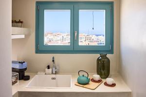 埃尔莫波利斯Syroc Maison的带水槽的厨房台面和窗户
